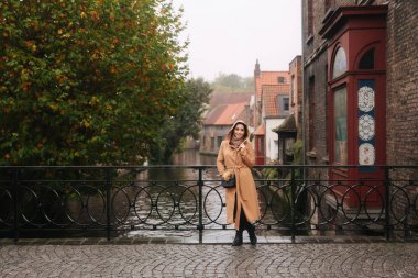 Bealgium, Brugge köprü üzerinde duran kahverengi ceketşık kadın. Kadın bir başlık koymak