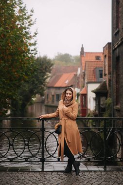 Bealgium, Brugge köprü üzerinde duran kahverengi ceketşık kadın. Kadın bir başlık koymak