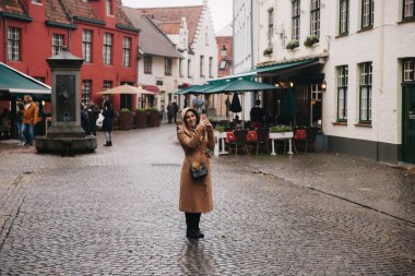 Bealgium, Brugge bir fotoğraf yapma kahverengi ceket güzel kadın portresi. Erkek bir başlık koymak