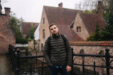 Belçika, Brugge 'de yürüyen genç bir adam. Erkek turist