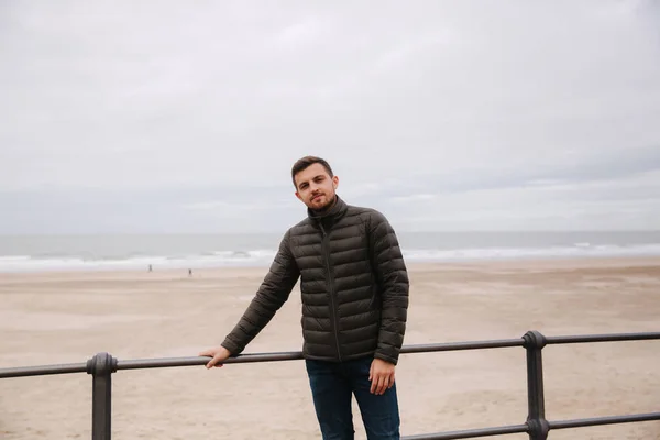 Un bel homme devant la mer du Nord. Homme élégant en veste kaki — Photo