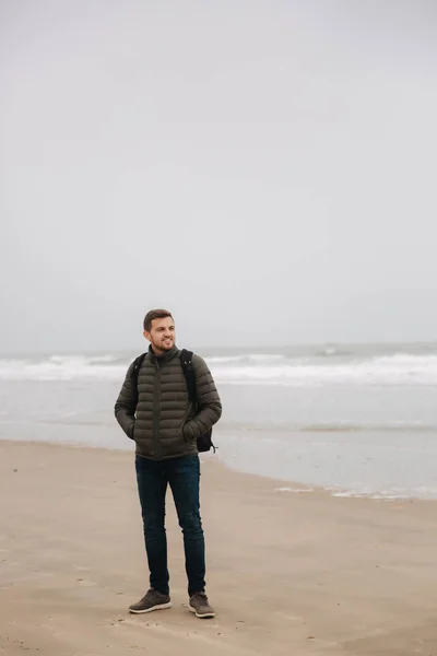 Paseo turístico masculino a lo largo del Mar del Norte. Hombre con mochila de pie en la costa en tiempo lluvioso. Hermoso mar — Foto de Stock