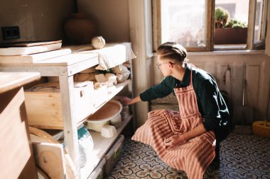 Çömlekçi adam iş için eşya arıyor. Genç adam atölyesinde çömlekçi. Yakışıklı adam işi.