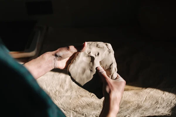 Il primo piano dell'uomo lavora con l'argilla. Maschio ceramista impasta e inumidisce l'argilla prima del lavoro, tonica — Foto Stock