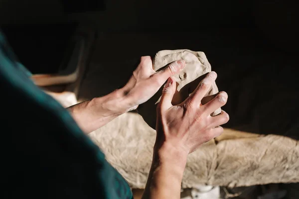 Close up of man works with clay. Male potter kneads and moistens the clay before work, toned — Stock Photo, Image