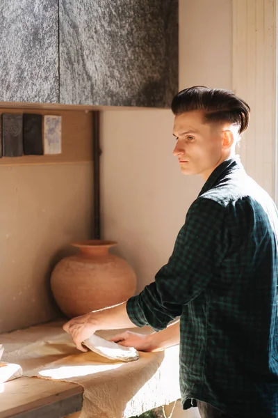 Mannelijke Potter werkt met keramiek in zijn atelier. Knappe jonge man werken binnen — Stockfoto