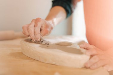 Kil kelebek damga. Seramik ürün. Masanın üzerinde adam el