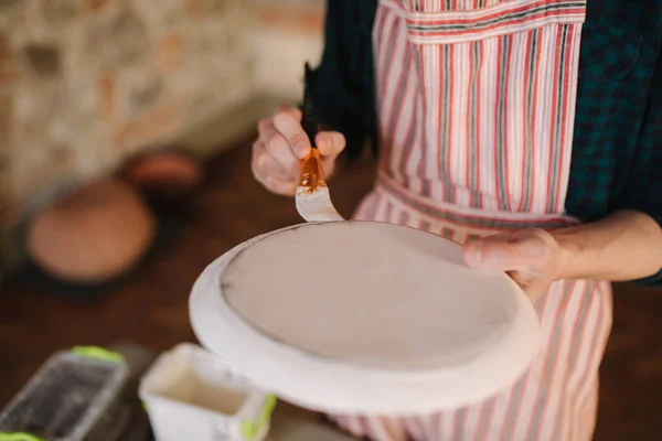 Närbild av keramiker händer gör prydnad på keramiska produkt. Tallrik i manliga händer. Ung konstnär — Stockfoto