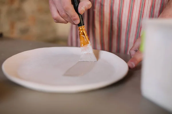 Close-up de oleiros mãos fazendo ornamento no produto cerâmico. Placa em mãos masculinas. Jovem artista — Fotografia de Stock