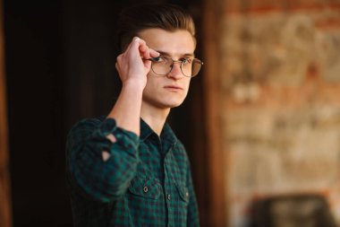 Young man in glasses and green shirt inside