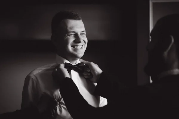 Happy groom stand by the window at home. Morning of groom. Handsome man in suit — Stock Photo, Image