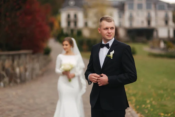 Casal elegante wolking no parque em seu dia do casamento. Feliz recém-casados fora em clima de outono — Fotografia de Stock