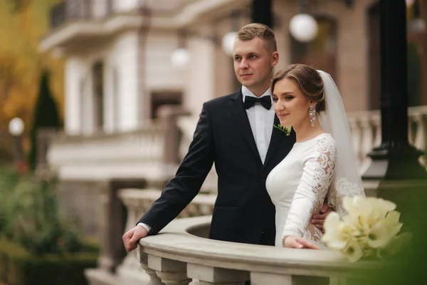 Casal lindo stand na varanda. Noiva elegante e noivo no outono tempo fora — Fotografia de Stock