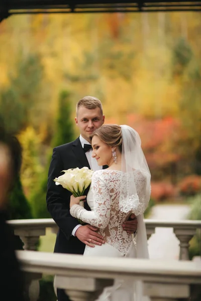 아름다운 웨딩 커플은 발코니에 서 있습니다. 외부 가을 날씨에 세련된 신부와 신랑 — 스톡 사진