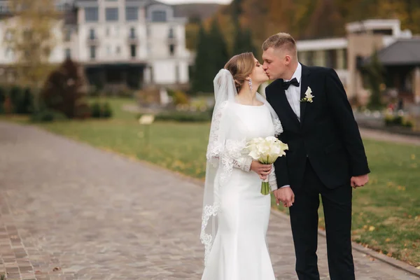 Casal elegante wolking no parque em seu dia do casamento. Feliz recém-casados fora em clima de outono — Fotografia de Stock