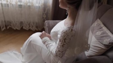 Evde sandalyede oturan muhteşem gelin. Gelinlik güzel kadın