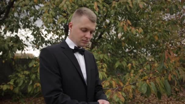 Молодой человек в костюме стоит снаружи — стоковое видео