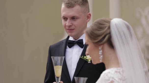 Los recién casados secan el champán en la ceremonia de boda — Vídeo de stock