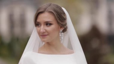 Dışında zarif gelinlik güzel gelin kadar kapatın. Kameraya poz veren büyüleyici kadın