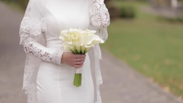 Bliska piękna panna młoda w eleganckiej sukni ślubnej na zewnątrz. Urocza kobieta pozowanie do kamery — Wideo stockowe