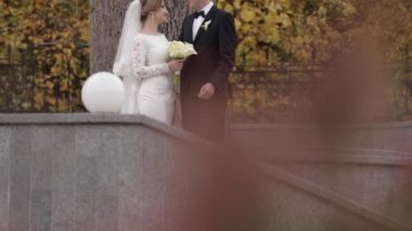 Mutlu yeni evliler parkta yürüyor. Zarif gelin ve handome damat dışında