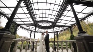 Happy wedding couple stand on beautiful balcony by the palace