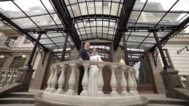 Happy wedding couple stand on beautiful balcony by the palace
