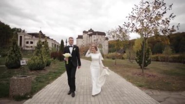 Yakışıklı damat ve sevimli gelin parkta düğün töreninden sonra birlikte vakit geçirmek