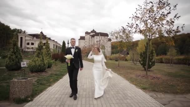Schöner Bräutigam und charmante Braut verbringen Zeit miteinander nach der Trauung im Park — Stockvideo