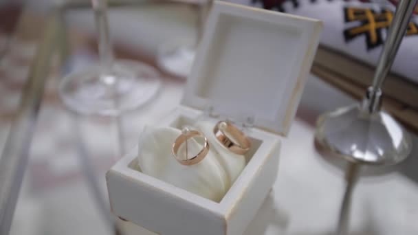 Anéis de casamento de ouro na mesa — Vídeo de Stock