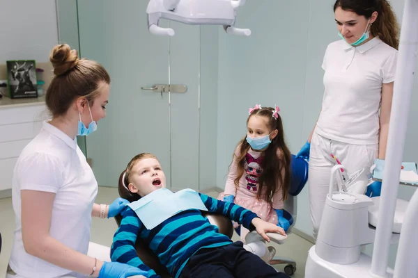 Pediatric dentist with assistant with little boy and girl — Stock Photo, Image