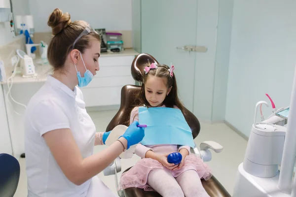 Dentist show to little girl how to wash teeth