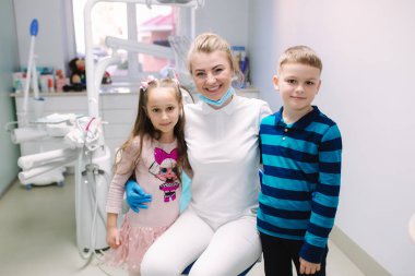 Klinikte dişçi olan küçük bir oğlan ve kız. Mutlu çocuklar