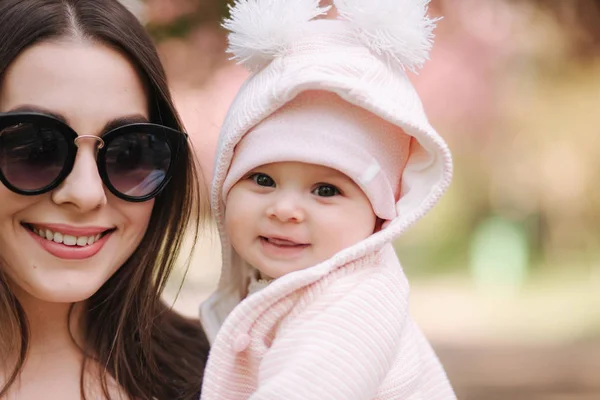 Portretul unei fetiţe drăguţe afară cu mama. Frumoasă fată zâmbet. Copil de cinci luni. Familie fericită — Fotografie, imagine de stoc