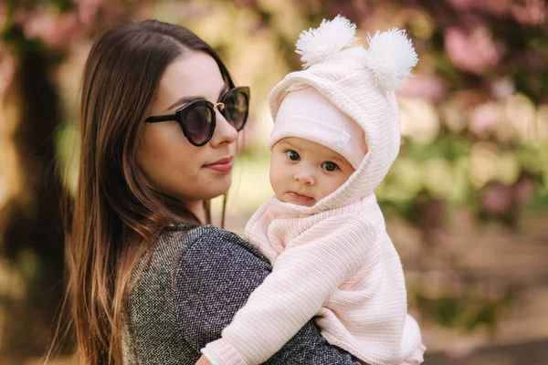 Porträtt av söt liten baby flicka utanför med mamma. Vacker flicka leende. Fem månaders bebis. Lycklig familj — Stockfoto