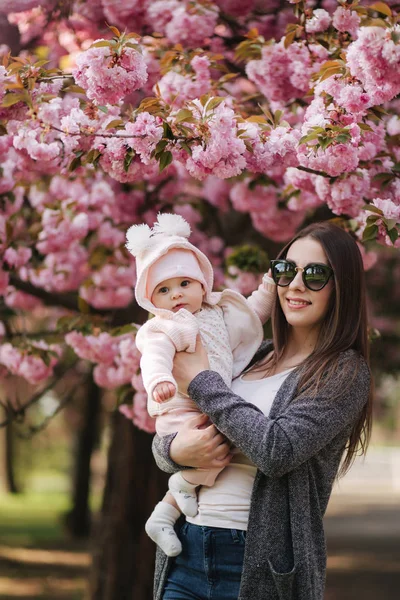 Anya kislánya a parkban séta a Sakura fa — Stock Fotó