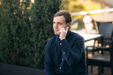 Koyu renk gömlekli genç adam birini ara. Yakışıklı adam.