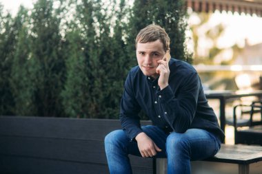 Koyu renk gömlekli genç adam birini ara. Yakışıklı adam.