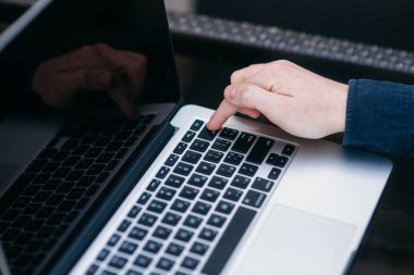 Dizüstü bilgisayar kullanarak adam orta seçim ve düğmeye parmak koymak