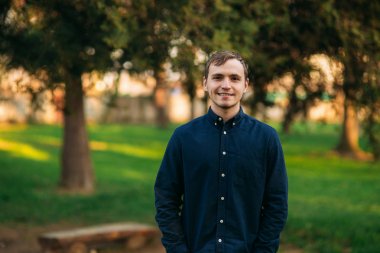 Parkta duran lacivert gömlekli adam