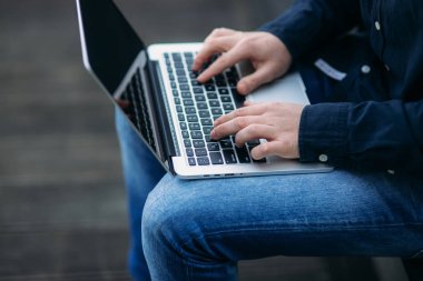 Man'in dizüstü bilgisayarında yazarak yakınlanın. Koyu renk gömlek