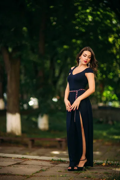 Mulher elegante em vestido azul escuro stand no parque — Fotografia de Stock