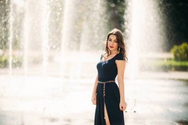 Şehirde çekici genç model yürüyüş. Çeşmenin arka planı