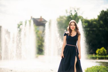 Şehirde çekici genç model yürüyüş. Çeşmenin arka planı