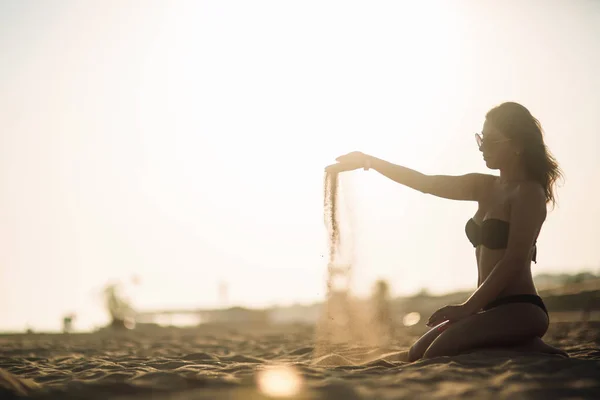 Сексуальна дівчина купається на пляжі і грає з піском — стокове фото