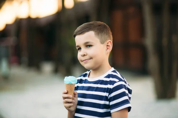 Egy kis fiú a csíkos póló kék fagylalt eszik. Tavasz, napsütés — Stock Fotó