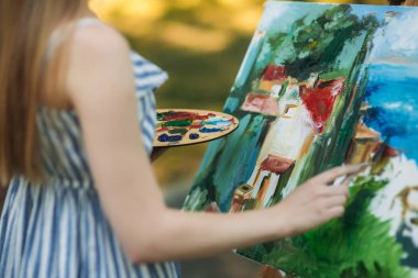 Parkta bir resim çizen güzel sarı saçlı kız geri görünümü. orta celection