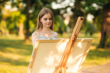 Parkta bir resim çizim elbiseli sarışın kız