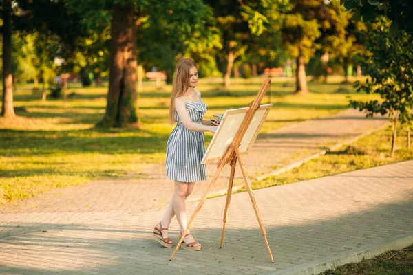 Blondes Haar Mädchen im Kleid zeichnet ein Bild im Park — Stockfoto