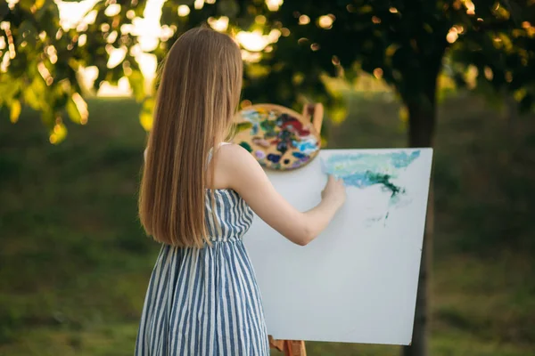 Rückseite der blonden Haare Mädchen im Kleid Zeichnung eines Bildes im Park — Stockfoto